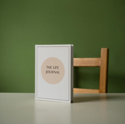 A5 Hardback White and Beige The Life Journal, Green background on a table